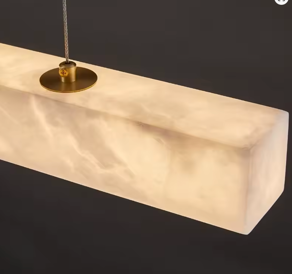 Marble pendant light with gold fixture on a dark background