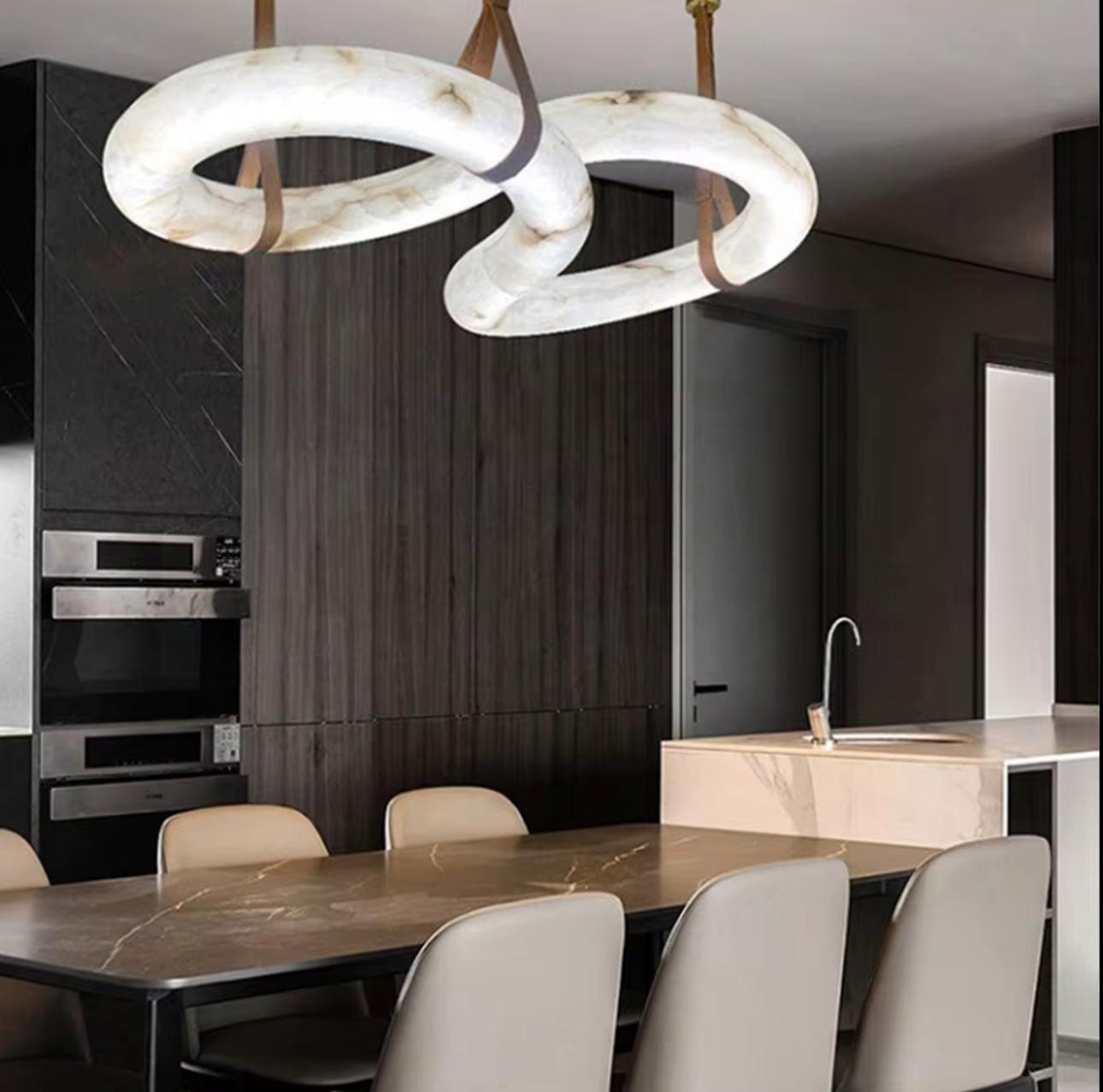 Modern kitchen with a stylish pendant light fixture above a dining table.