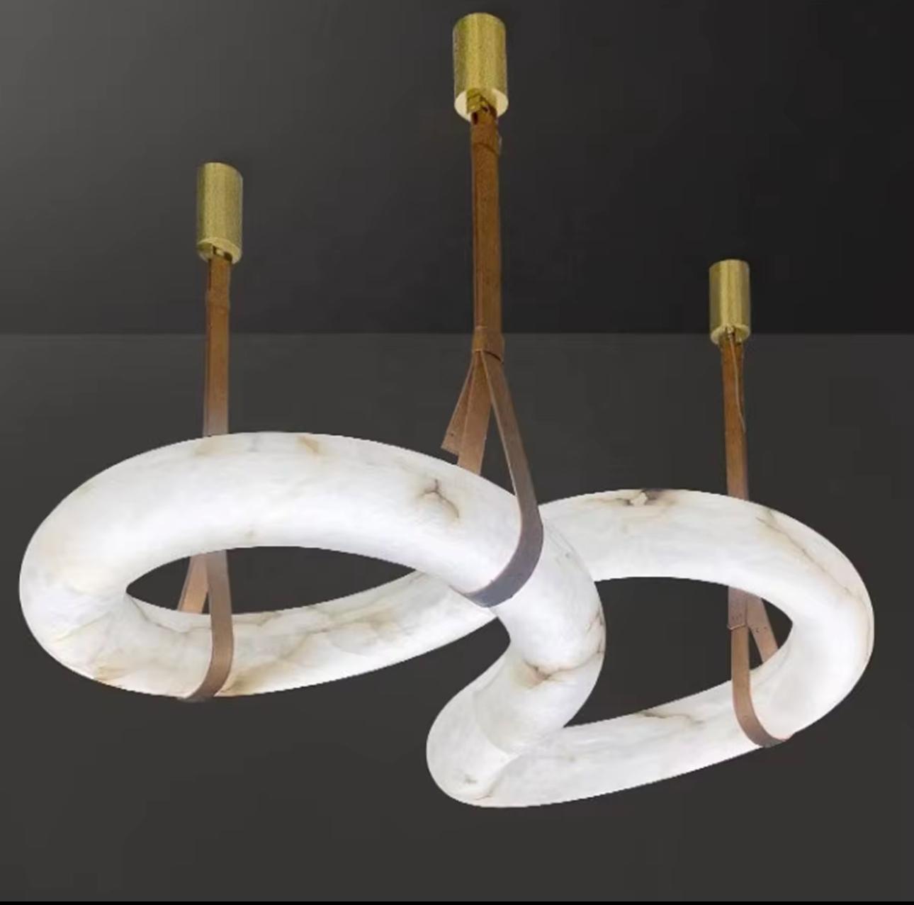 Modern chandelier with marble-like rings and gold accents on a dark background
