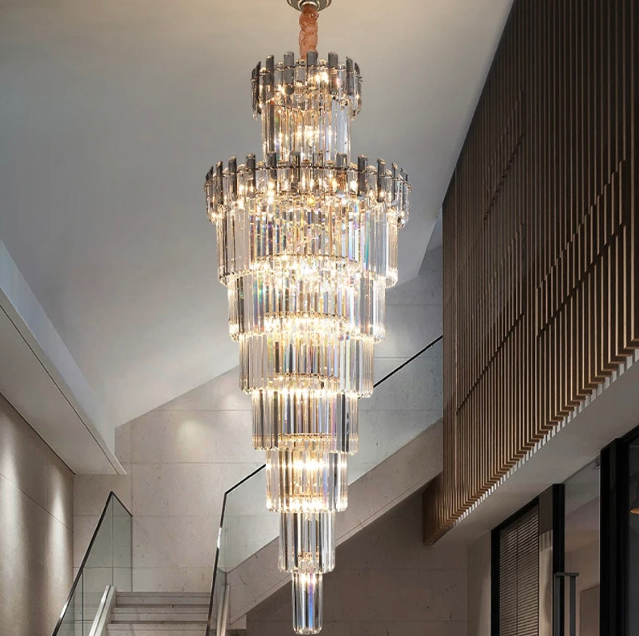 Large modern crystal chandelier creating a stunning focal point in a high-ceiling space