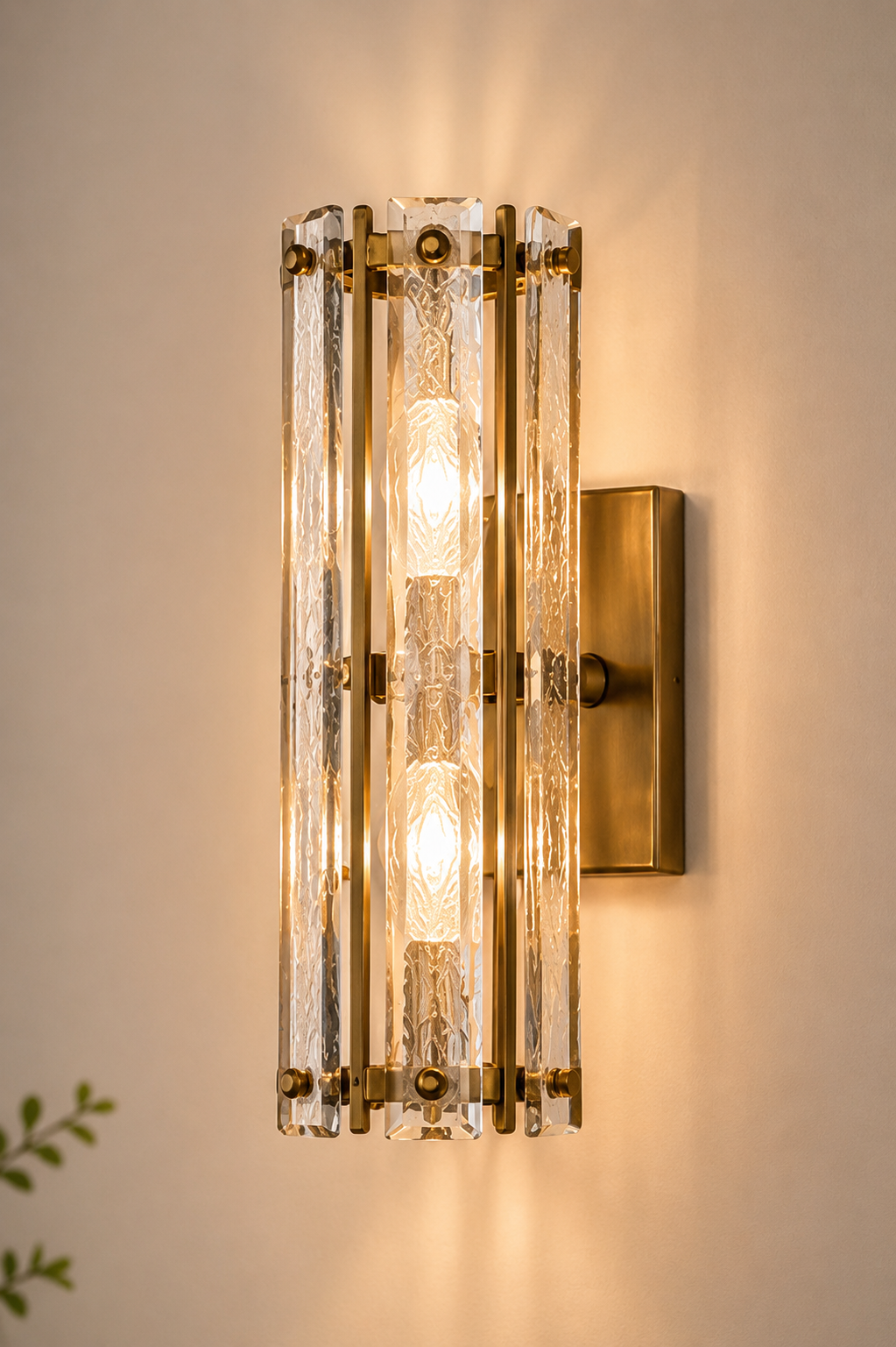 Decorative wall sconce with glass panels and gold accents on a neutral wall.