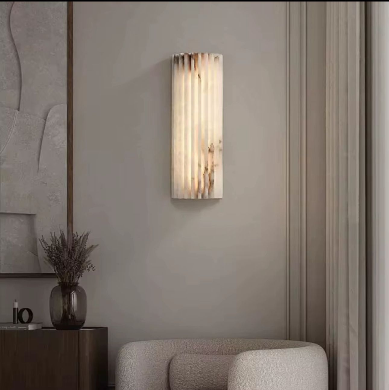 Modern wall sconce in a stylish interior setting with a vase and abstract art.